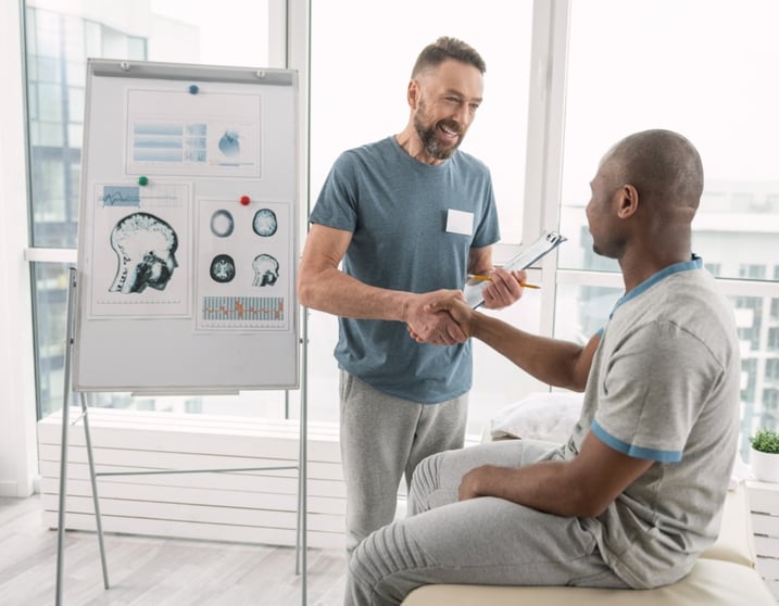 mature doctor shaking hands with black male patient-big-1